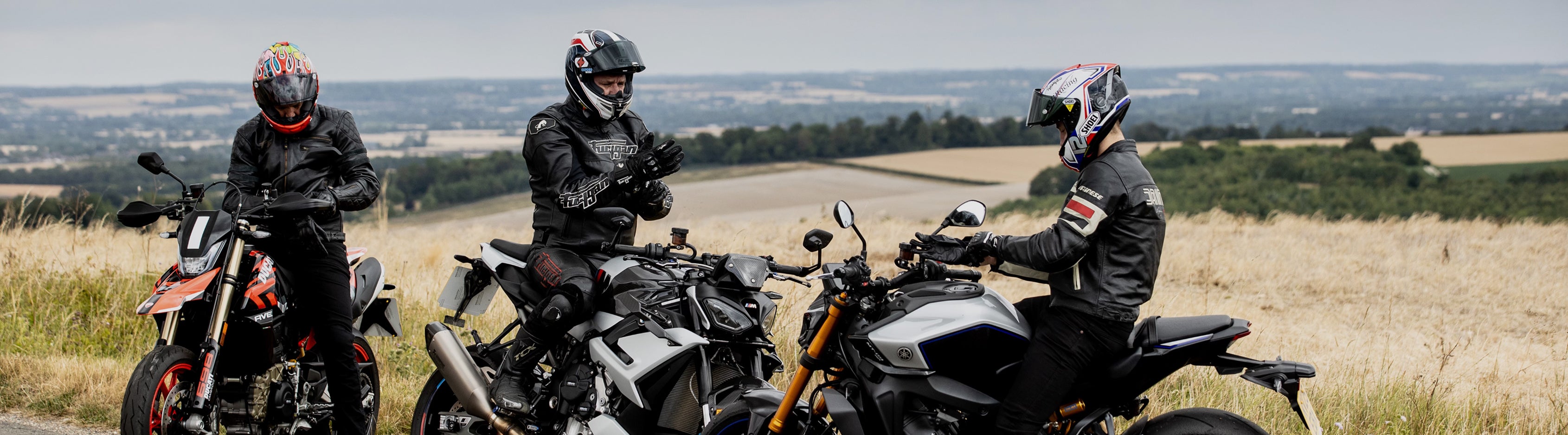 Three motorcyclists on a scenic landscape with their motorcycles. GBRacing.