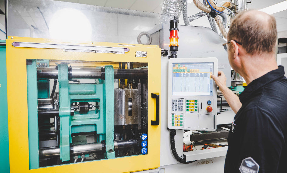 Person operating a machine with a digital display in a workshop setting